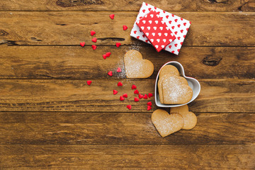 Heart shaped cookies with gifts over wooden background. Valentine day - homemade festive decorated pastry biscuits cookies