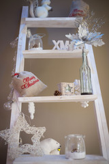 Fototapeta na wymiar White Christmas decorations on a wooden ladder