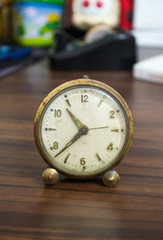 Old table clock on brown table