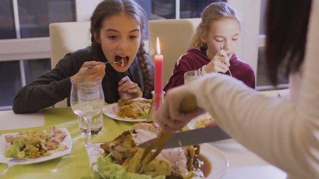 Woman cuts fried chicken at the festive table