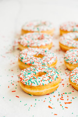 Donuts with white chocolate cream and sprinkles sugar