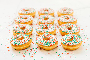 Donuts with white chocolate cream and sprinkles sugar