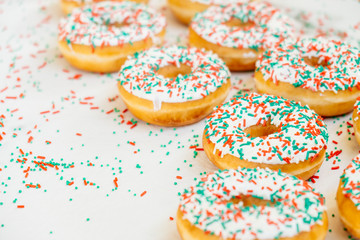 Donuts with white chocolate cream and sprinkles sugar