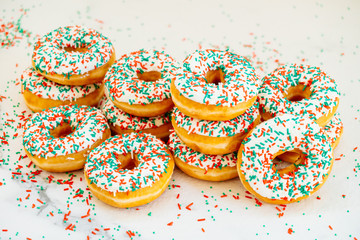 Donuts with white chocolate cream and sprinkles sugar