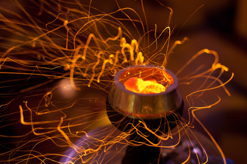 Coals in a hookah with sparks.