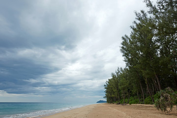 Dramatic seascape. Deserted beach and forest in Thailand and thunder sky.