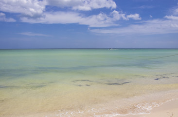 Personal Watercraft zooms along near the horizon of a turqoise sea meeting the blue sky