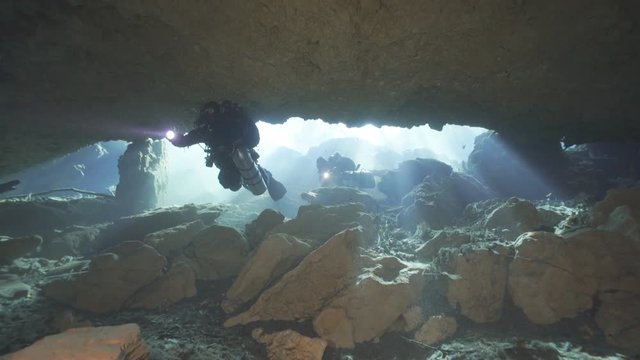Rebreather divers entering to fresh water cave