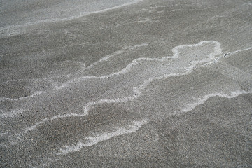 winter ice melting salt on the ground, pattern as background