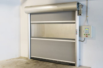 Roller shutter door and concrete floor inside factory building for industrial background.