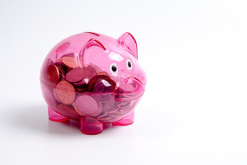 Coins in the red piggy bank isolated on white. Saving and investment conceptual.