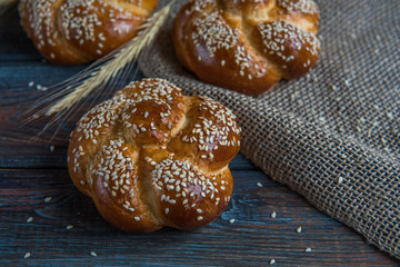 Buns with sesame seeds on a wooden background top view