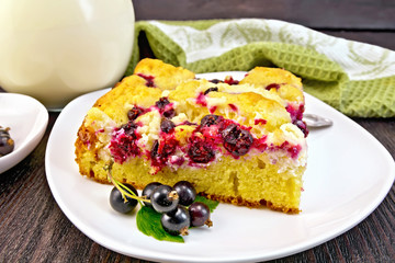 Pie with black currant in plate on dark board