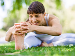 Fototapeta premium Young woman practicing yoga in the park