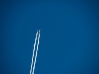 jet fly over blue sky with 2 white trails behind