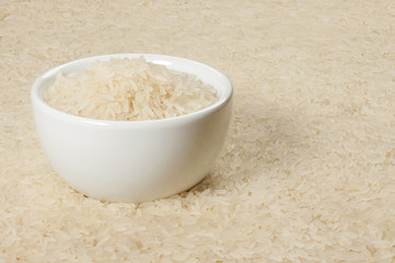 A cup of white rice on a table with rice