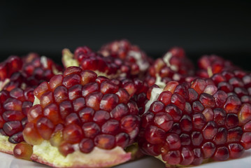 Red juicy pomegranate close up on black background