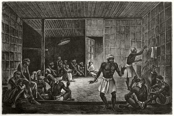 Ancient Borneo natives celebrating an exorcism indoor in a dark hut. Old illustration of Ot Danum people rite in Borneo. Created by Lancon after Schwaner published on Le Tour du Monde Paris 1862