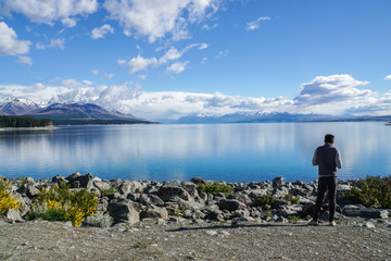 Fototapeta na wymiar man at outdoor with clear blue lake and mountain range in New Zealand