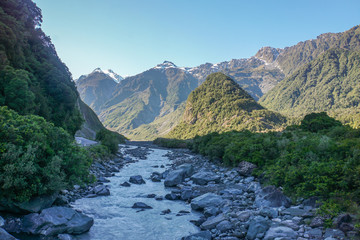 river along the green hill in sunny day