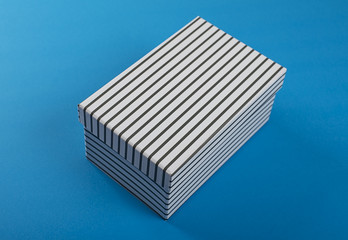 White shoe box with black stripes on blue background. Mockup.