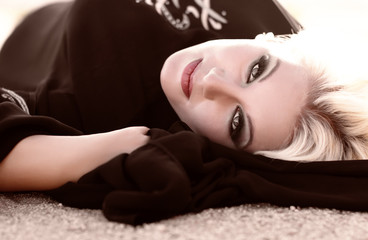 Naklejka premium Sexy woman with blond curly hair and deep eyes with long eyelashes, red lips, attractive horny look, fashion beauty, beautiful bright make up, plus size model, erotic big fat girl in black arab dress