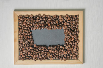 Coffee beans in a wooden frame on a white background top view, free copy space