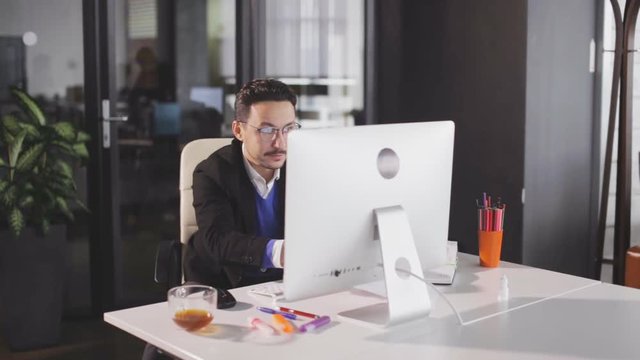 Successful businessman juming and raising hands in the office