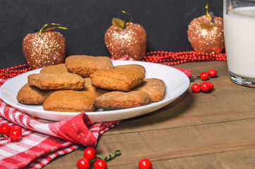 Biscuits, milk, red napkin, Christmas decor with free space for text.