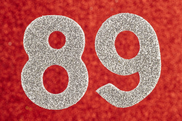 Number eighty-nine silver color over a red background. Anniversary
