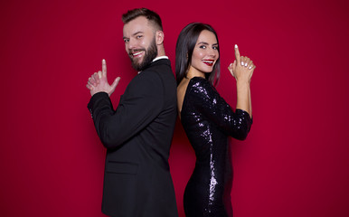 Beautiful couple in black luxury dress on a red background. Valentine's Day. Women's Day. March 8