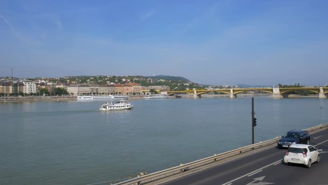 Small tour boat sailing river Danube towards Margaret Bridge in Budapest, Hungary