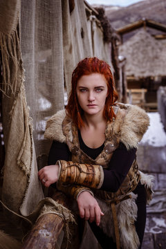 Viking woman with hammer in a traditional warrior clothes.