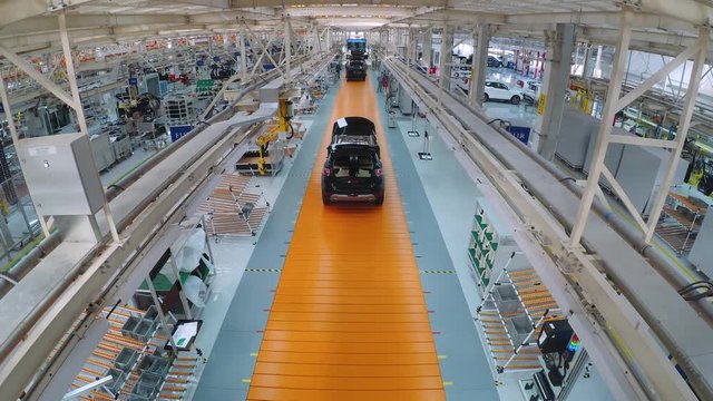 Automobile plant, modern production of cars, car body assembly process, workers serve cars, automated production line. Timelapse.
