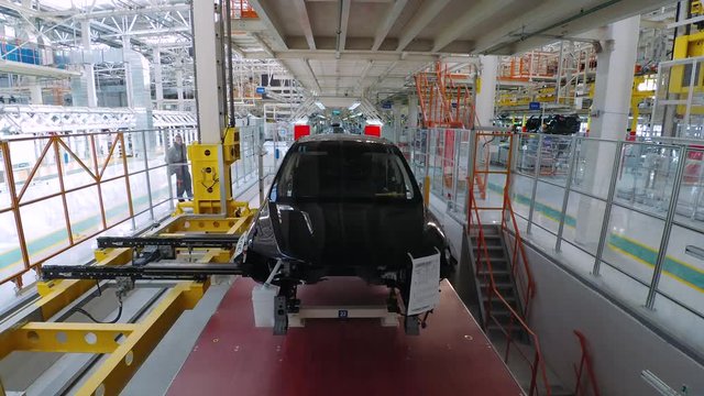 Automobile plant, modern production of cars, car body assembly process, workers serve cars, automated production line. Timelapse.
