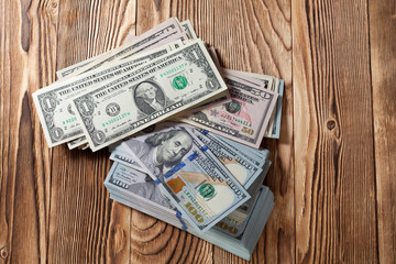 a purse with the American dollars is isolated on a wooden background