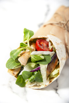 Fresh tortilla wrap with vegetables and roasted chicken. Gourmet concept. 