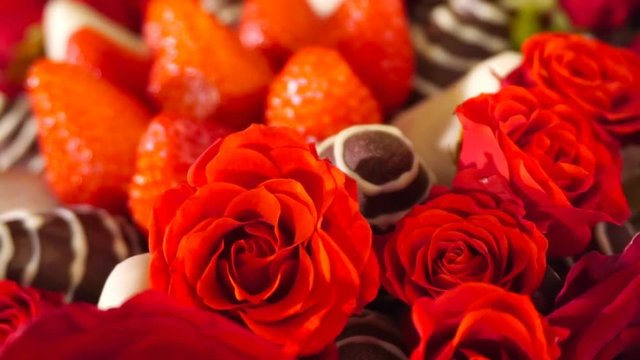 Rotation beauty bouquet with rose and strawberry in chocolate frosting. Slow motion.