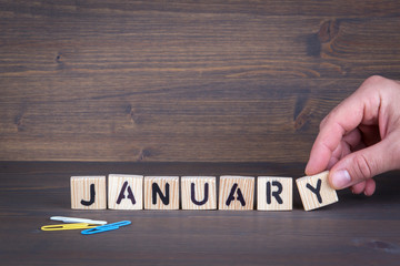 january. Wooden letters on the office desk, informative and communication background.