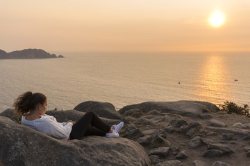 Chica viendo la una puesta de sol en frente de Islas Cies (Pontevedra, España).