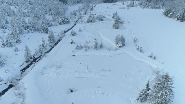 Aerial shot along the river among the Carpathian Mountains in winter 4K