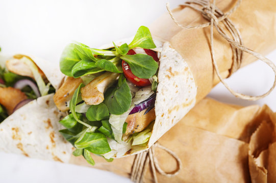 Fresh tortilla wraps rolled in a brown paper and tied round with string. Gourmet concept.