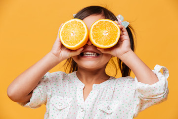 Little girl child covering eyes with orange.