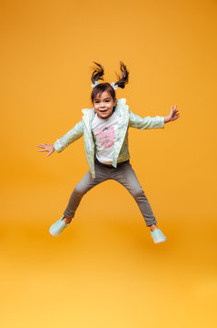 Cheerful little girl child jumping isolated
