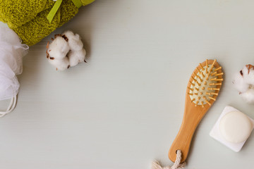 Spa ingridients on white wooden background. Wisp of bast, comb, natural soap and towel with a copy...