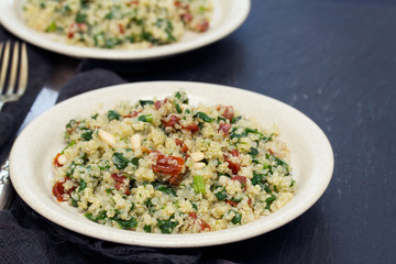 salad quinoa with kale and dried tomato on white plate
