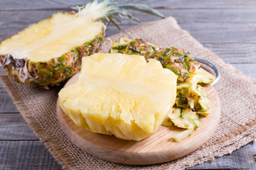 Fresh pineapple fruit and pineapple slice on wooden table