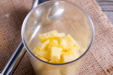 Pineapple slices in a blender on the table