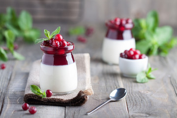 Homemade coconut Panna Cotta with cranberry sweet souce and fresh mint