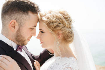 Wedding couple stands on the cliff before the sea